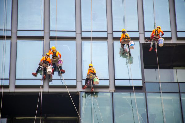 Bangkok, Thailand - Sep 25, 2019: Group of workers cleaning windows service on high rise building - High building and Risk working.